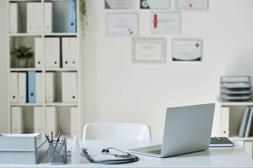 clinic with stethoscope, laptop, and records
