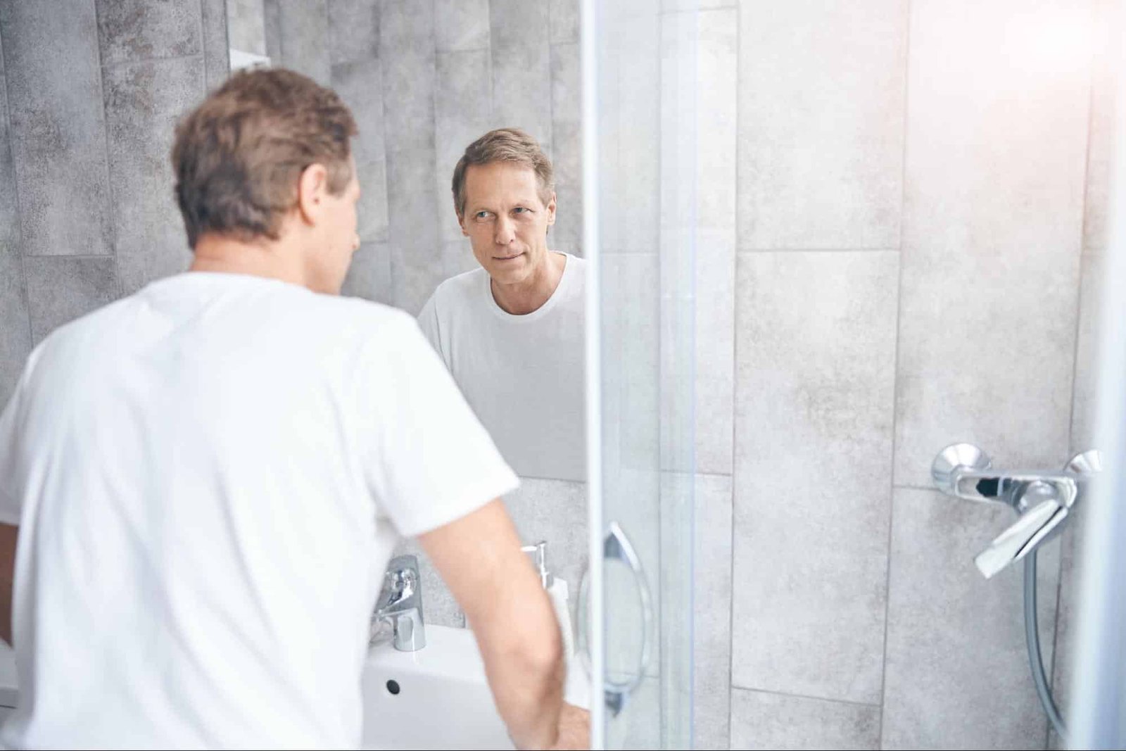 man looking at himself in a mirror