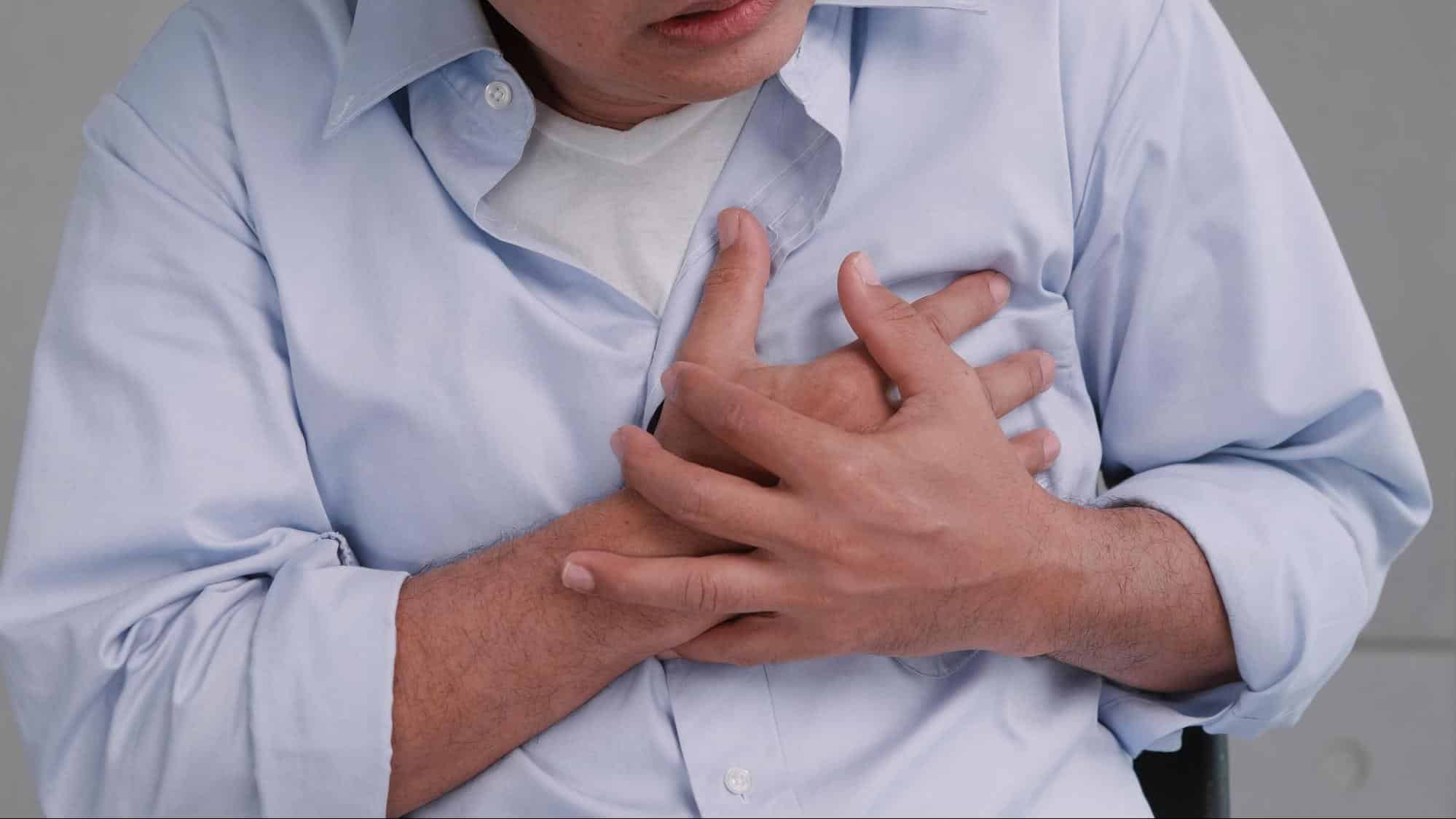 Man holding his chest in pain illustrating a potential medical emergency, highlighting when to go to the ER instead of an after hours clinic in Weslaco TX.