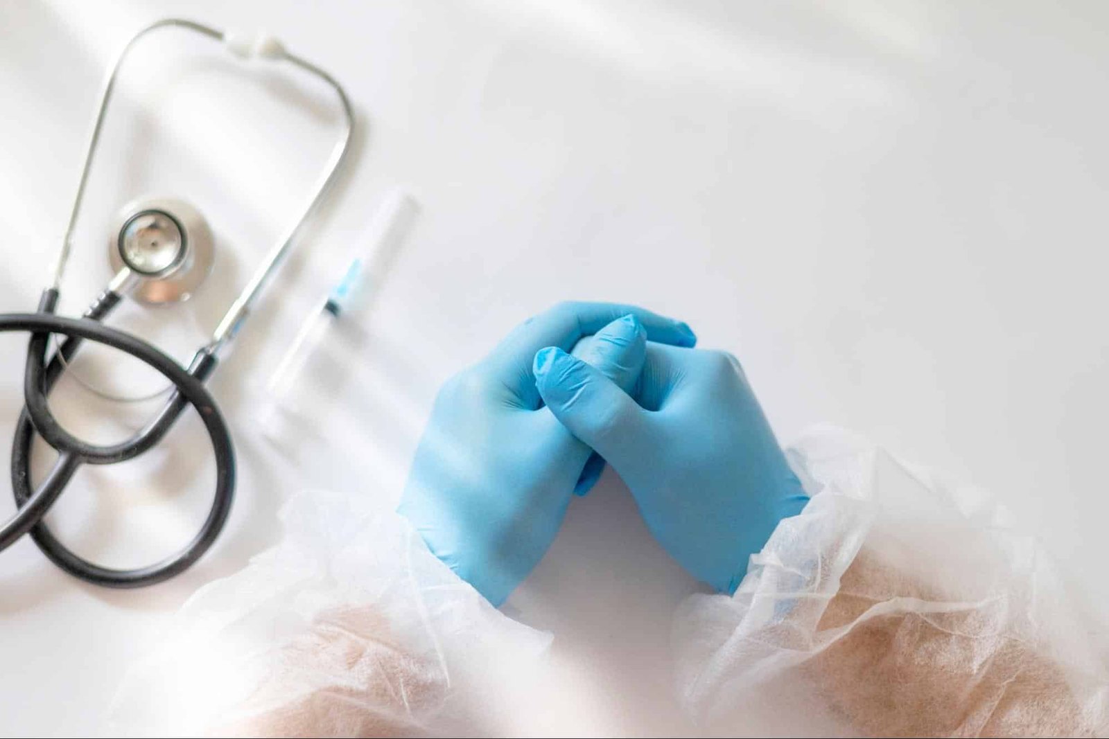 primary care provider in gloves and protective suit, with syringe and stethoscope