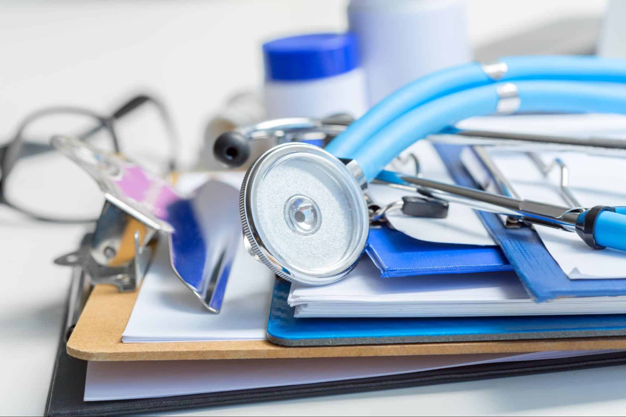 Stethoscope and medical forms on a clipboard