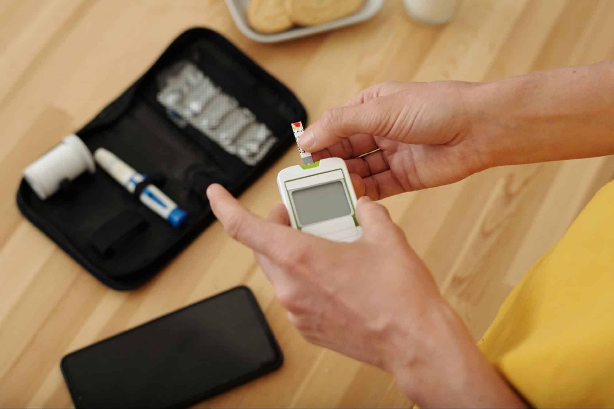 Person using a glucose meter to check blood sugar levels at home, representing chronic condition management at an after hours clinic in Weslaco TX.