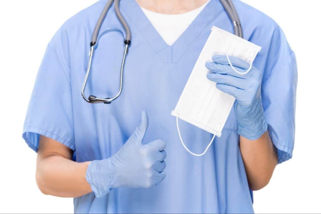 primary care provider making thumbs up sign, showing mask and wearing stethoscope, reflecting the value of Primary Care Services for Adults in Weslaco, TX
