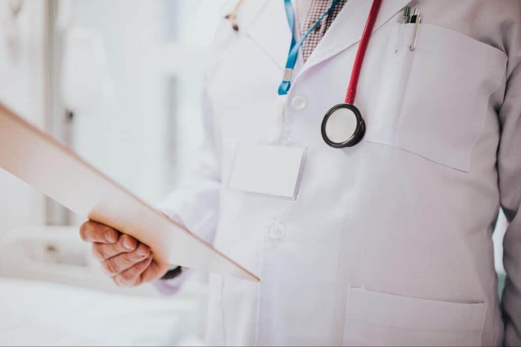 primary care provider with medical records, illustrating the importance of knowing the answer to How Often Should Adults Visit Primary Care?