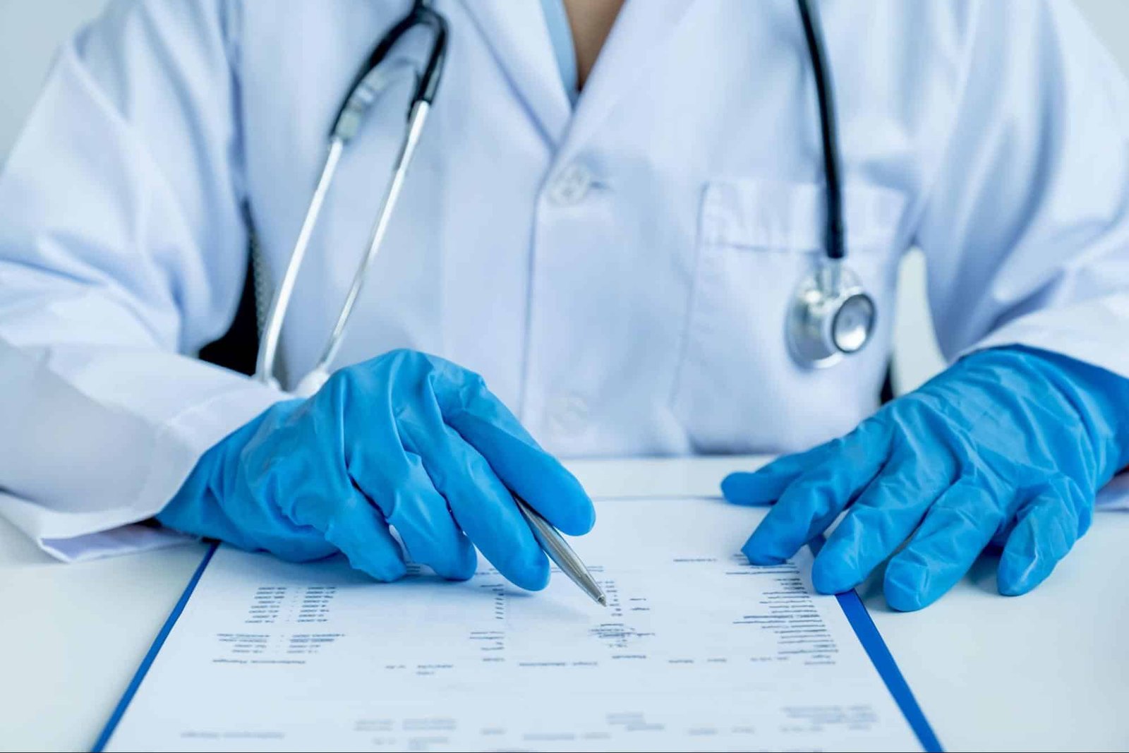 Primary care provider in gloves reviewing patient records during urgent care after hours in Weslaco