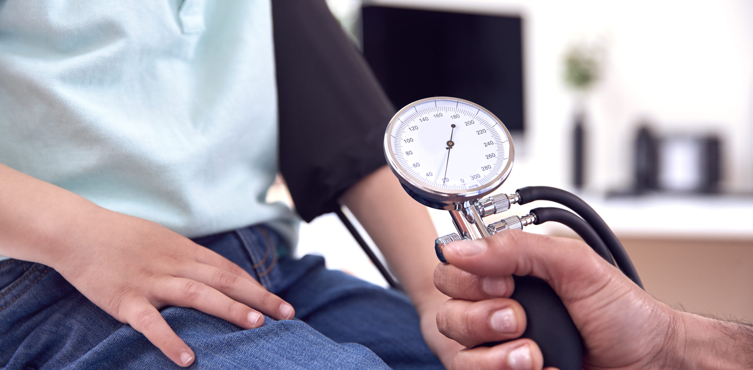 Medical professional checking a patient’s blood pressure with cuff and gauge during a high blood pressure care Weslaco appointment.