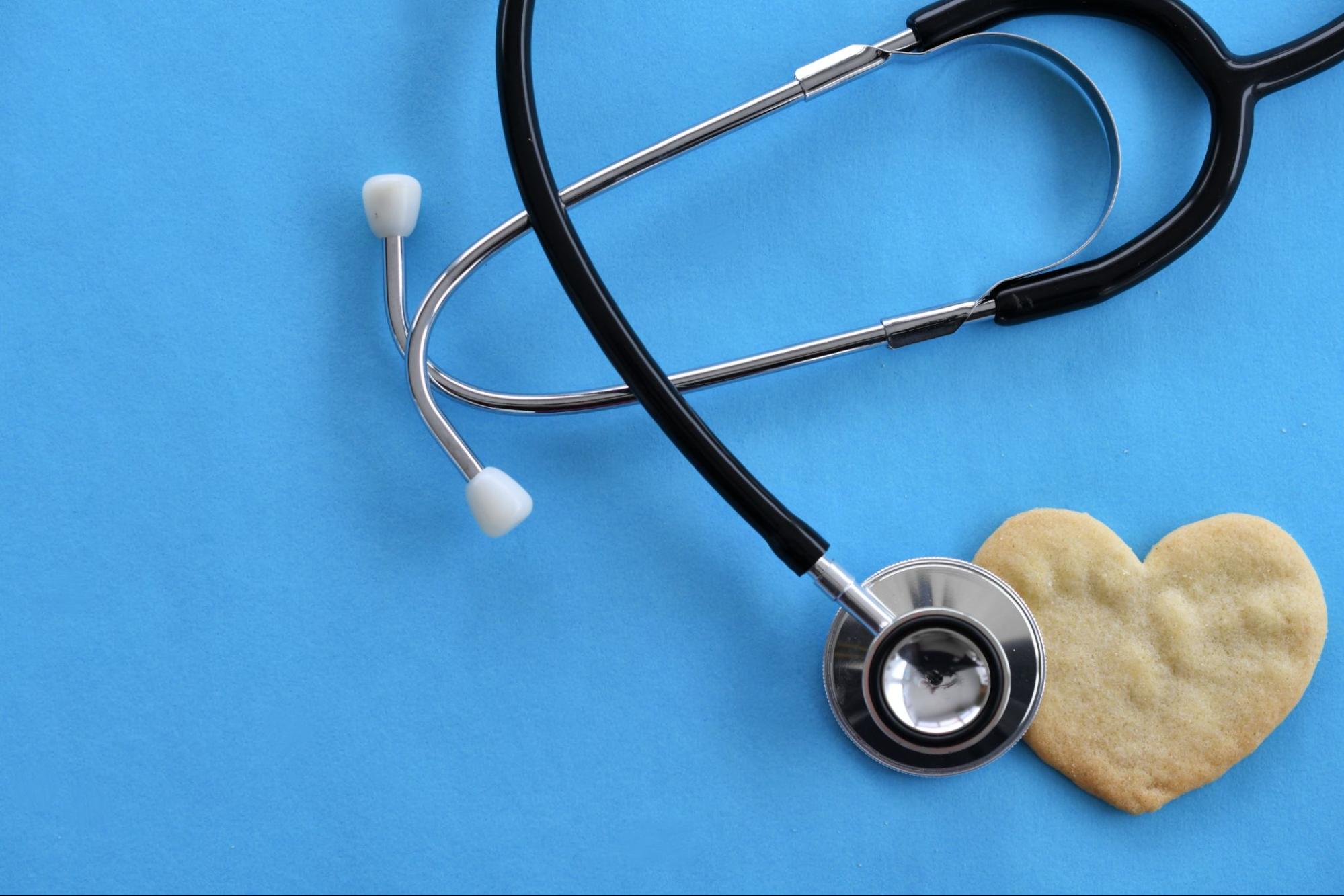 Stethoscope next to heart-shaped cookie symbolizing compassionate care