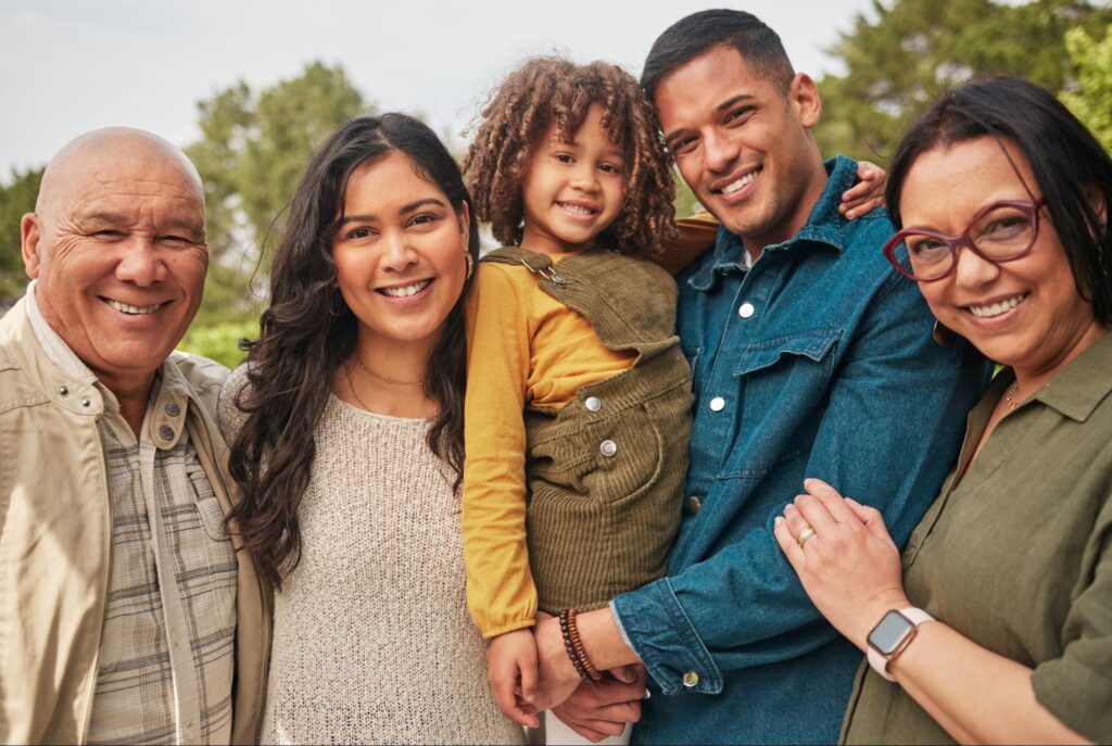 Multigenerational family smiling outdoors representing care from an evening clinic Weslaco TX