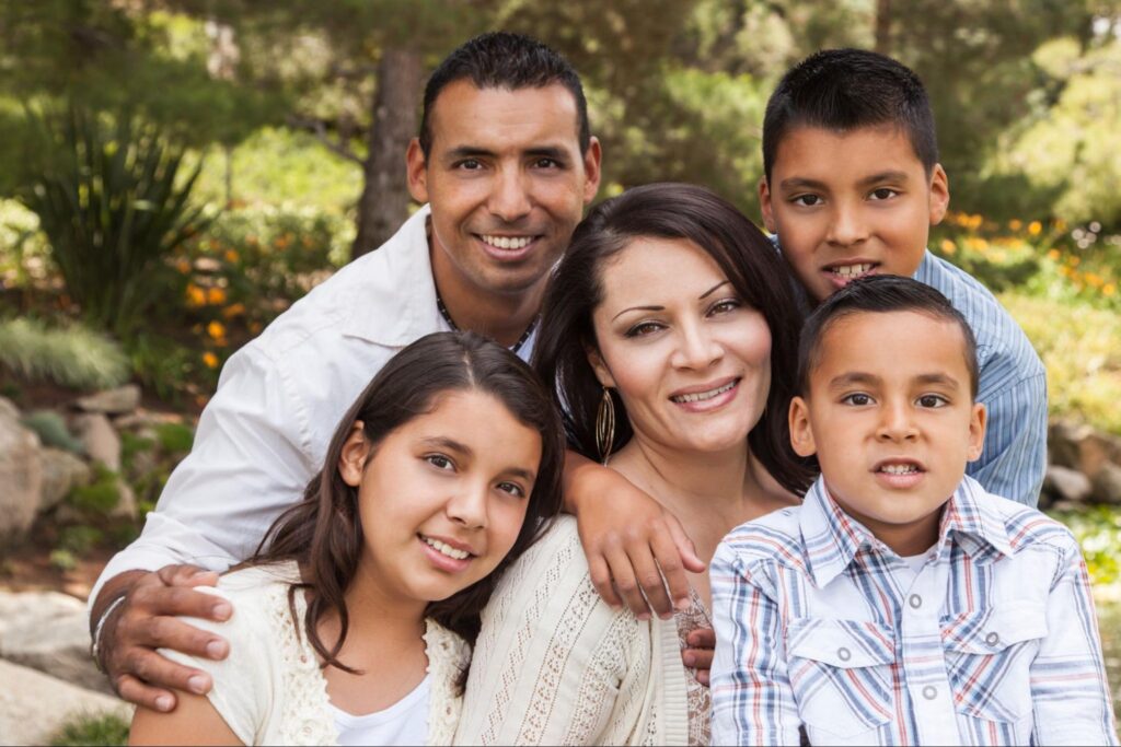 Happy family smiling outdoors, representing families using an after hours medical clinic in Weslaco TX