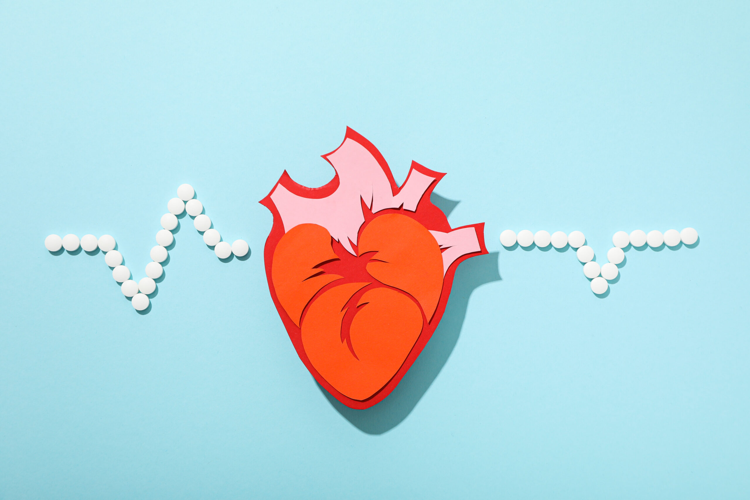 paper heart with ekg in pills, representing cholesterol screening in Weslaco TX