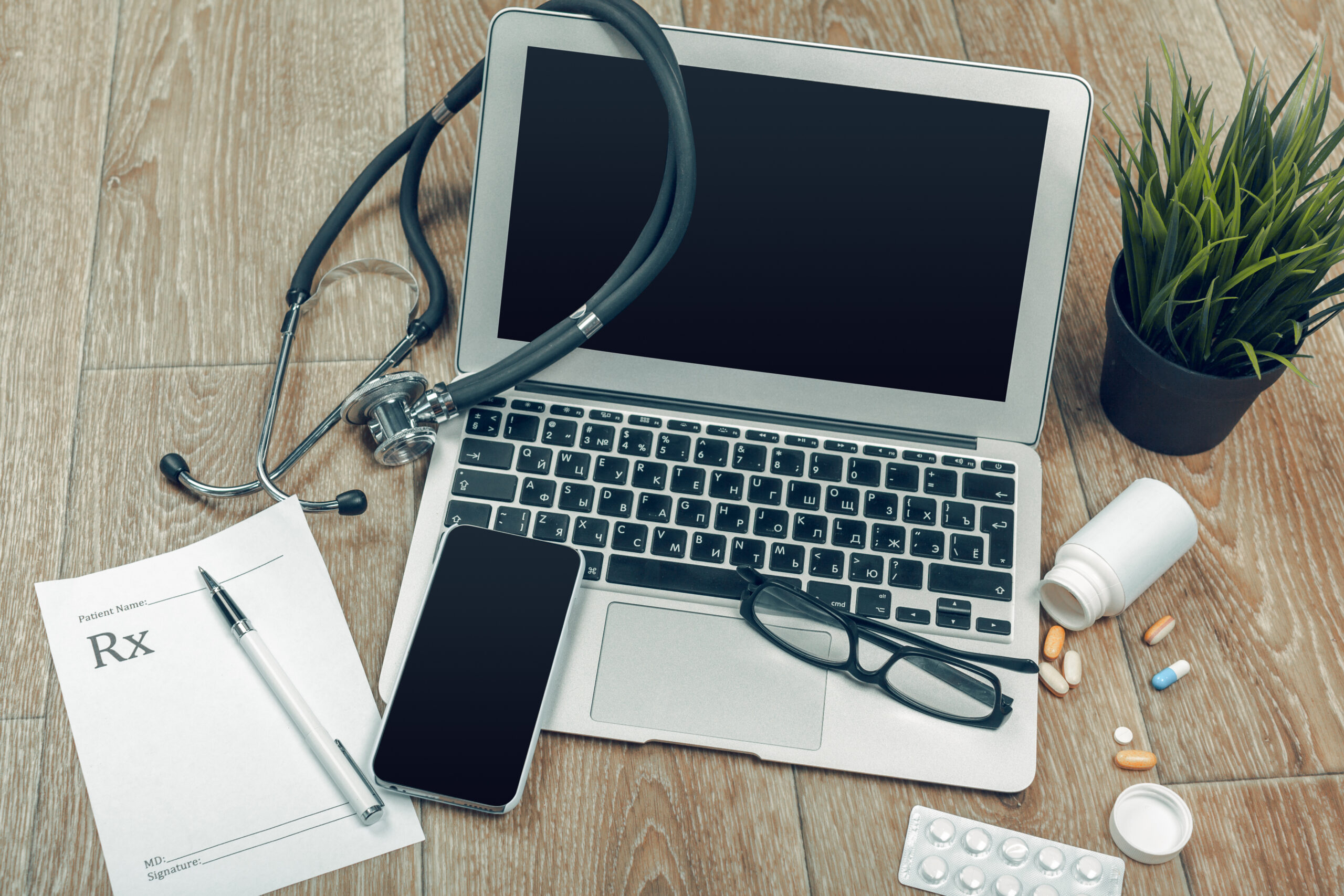 phone, laptop, prescription pad, and stethoscope, representing Telehealth primary care in Weslaco