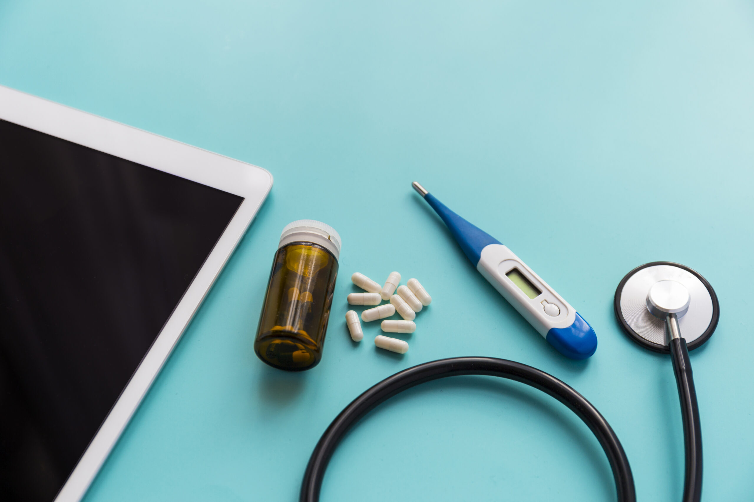 tablet with medicine and thermometer