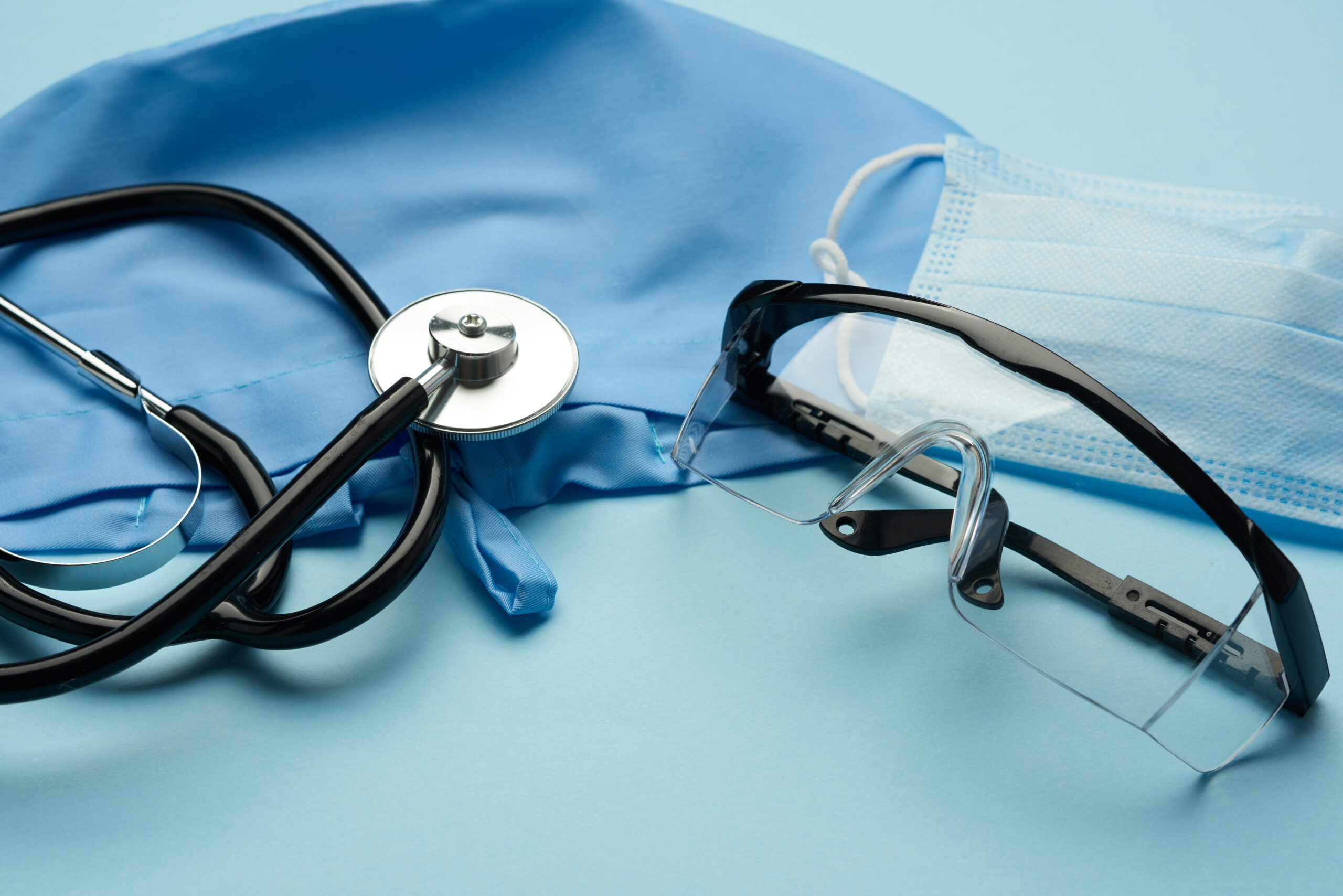 stethoscope, goggles, and mask on blue surface, representing the  question How to Book an Appointment at an After-Hours Clinic in Weslaco