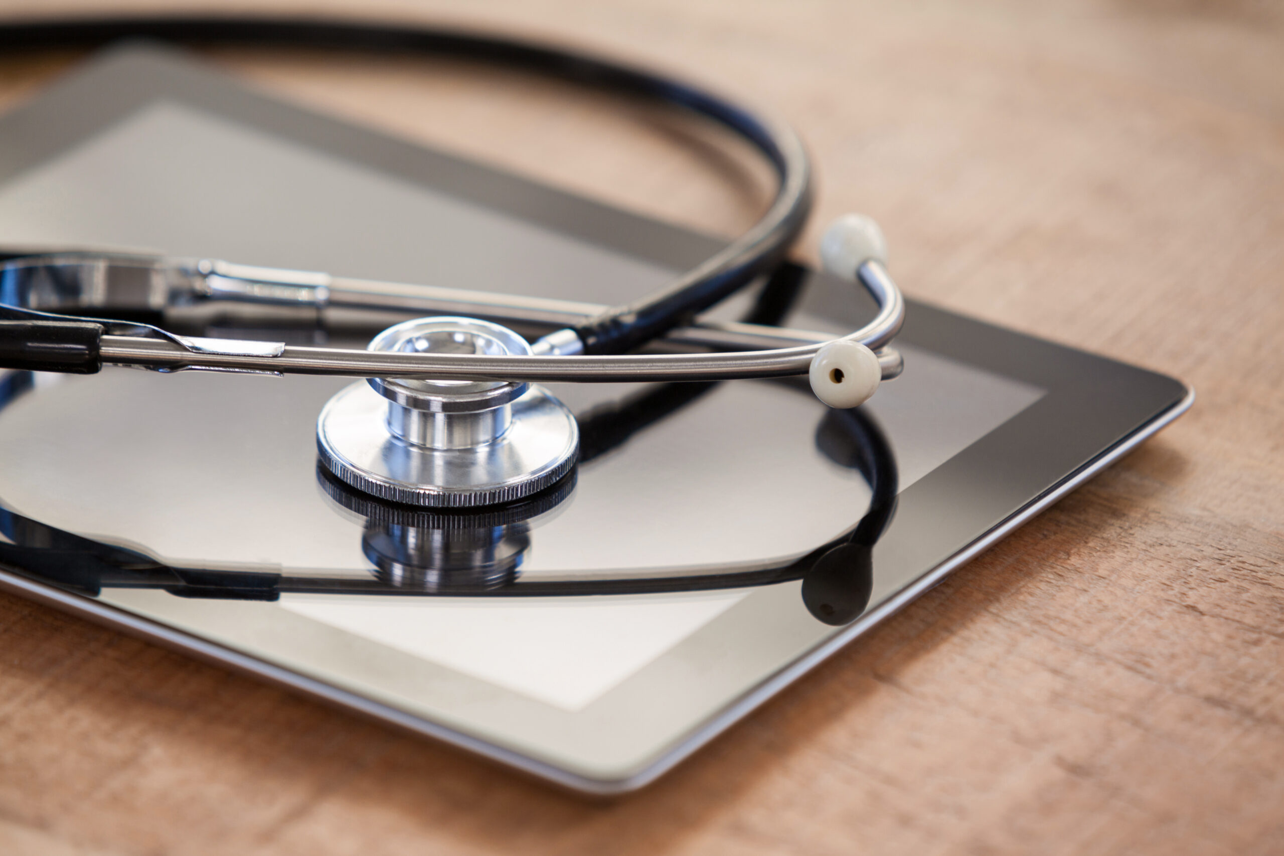 stethoscope on tablet on wooden table